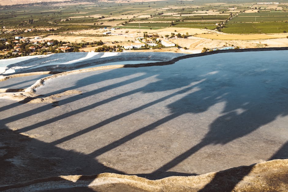 A stunning aerial view of Pamukkale's travertine terraces in Turkey during the day with shadows and sunlight.