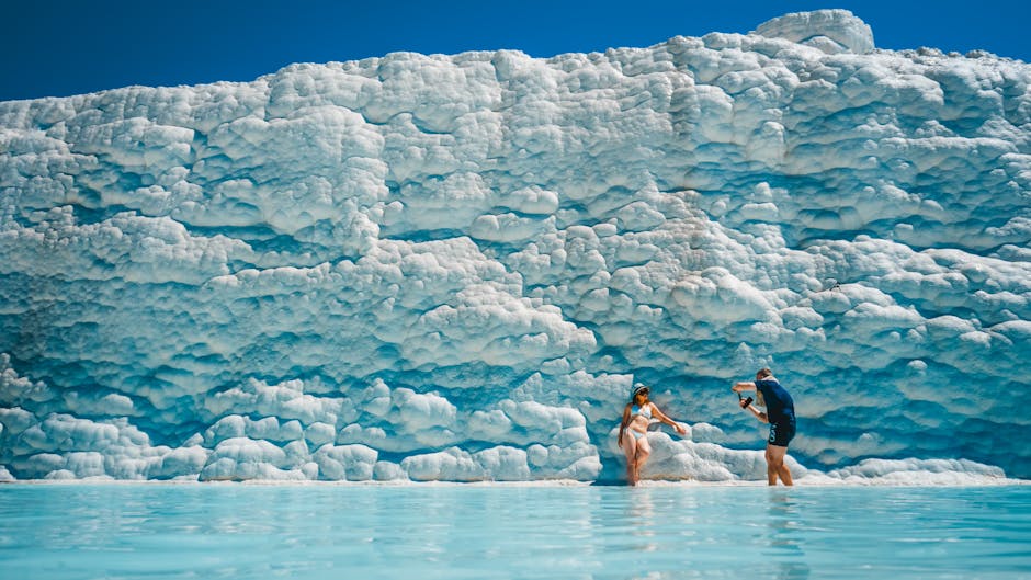 Visitors relax in the natural travertine pools of Pamukkale, a famous UNESCO World Heritage site in Turkey.