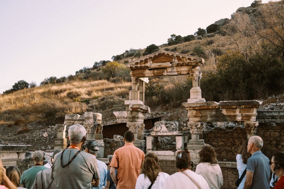 Group of tourists visiting ancient Roman ruins at Ephesus, Turkey during daytime.